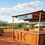 Feira do Trabalho e do Campo em Brazlândia com estandes de vagas de emprego e capacitações gratuitas em paisagem rural brasileira.