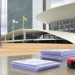 Fachada da CLDF em Brasília com editais de concursos e kit de primeiros socorros, ilustrando lei que complica seleções no DF.