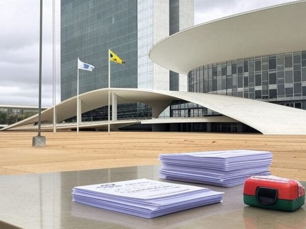 Fachada da CLDF em Brasília com editais de concursos e kit de primeiros socorros, ilustrando lei que complica seleções no DF.