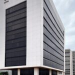 Prédio da Caesb em Brasília sob céu nublado, representando frustração com resultado provisório de concurso.