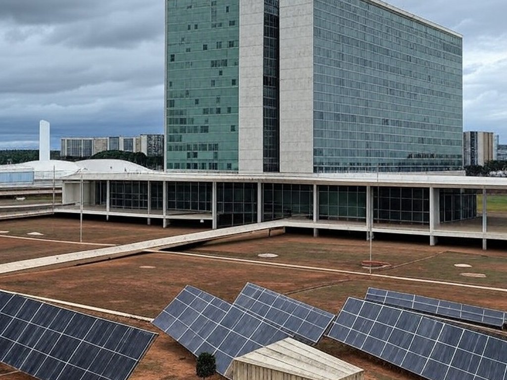 Edifício da CLDF em Brasília com elementos de energia de hidrogênio sob céu nublado, representando lei aprovada mas criticada como tardia.