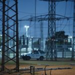 Subestação elétrica no DF com cabos danificados por tentativa de furto e viatura da Polícia Militar ao fundo.