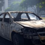 Carro carbonizado em rua de Brasília, DF, isolado por fita policial, cena de investigação criminal.