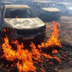 Carros danificados por incêndio em rua de Vicente Pires, com veículos de bombeiros brasileiros ao fundo.