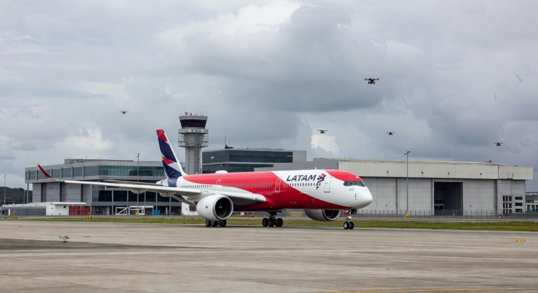 Avião da Latam na pista do Aeroporto de Guarulhos com drones no espaço aéreo.
