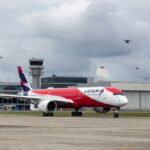 Avião da Latam na pista do Aeroporto de Guarulhos com drones no espaço aéreo.