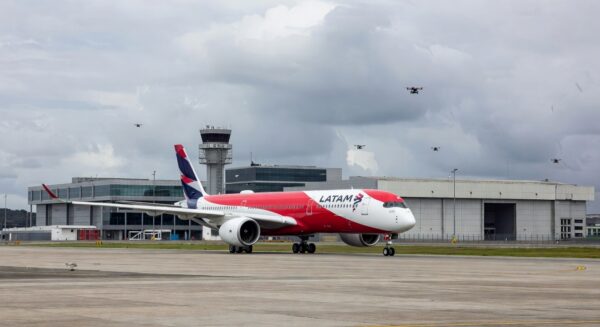 Avião da Latam na pista do Aeroporto de Guarulhos com drones no espaço aéreo.
