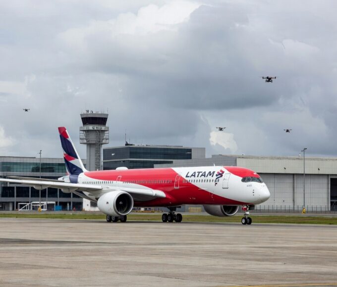 Avião da Latam na pista do Aeroporto de Guarulhos com drones no espaço aéreo.