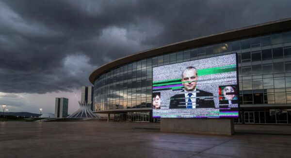 Sala de plenário vazia na CLDF com documentos espalhados e relógios parados, simbolizando atrasos em pautas urgentes.