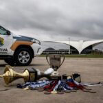 Viatura da Polícia Legislativa estacionada perto de campo esportivo em Brasília, representando foco desperdiçado em olimpíadas de segurança pública.