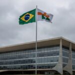 Edifício da Câmara Legislativa do DF em Brasília com bandeiras, representando homenagem controversa a ministro do TST em meio a críticas por desvio de recursos públicos.