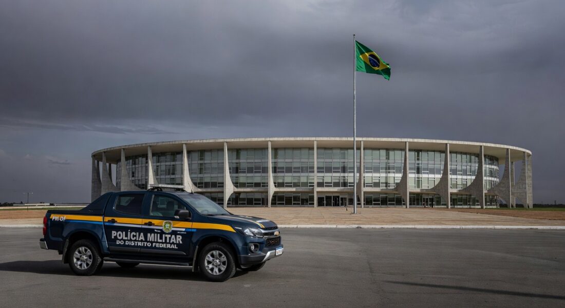 Viatura da PMDF em frente à CLDF em Brasília, destacando riscos na reintegração de policiais e violência contra mulheres.