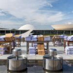 Evento em Brasília com bebedouros e documentos burocráticos, representando lei da CLDF sobre obrigatoriedade em eventos no DF.