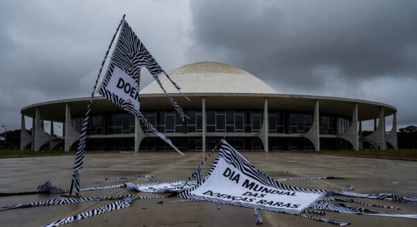 Fachada da CLDF com banners do Dia Mundial das Doenças Raras rasgados, expondo lacunas no apoio a pacientes.