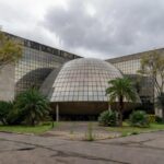 Edifício da CLDF em Brasília, com fachada moderna e sinais de negligência urbana, destacando prioridades ignoradas da população.