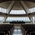 Igreja evangélica em Brasília com prédio da CLDF ao fundo sob céu nublado