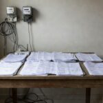 Contas de água, luz e internet sobre mesa representando lei do DF sobre dívidas