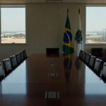 Sala de reuniões em Brasília com mesa e documentos representando encontro político