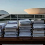 Documentos de precatórios do DF sobre mesa em ambiente institucional
